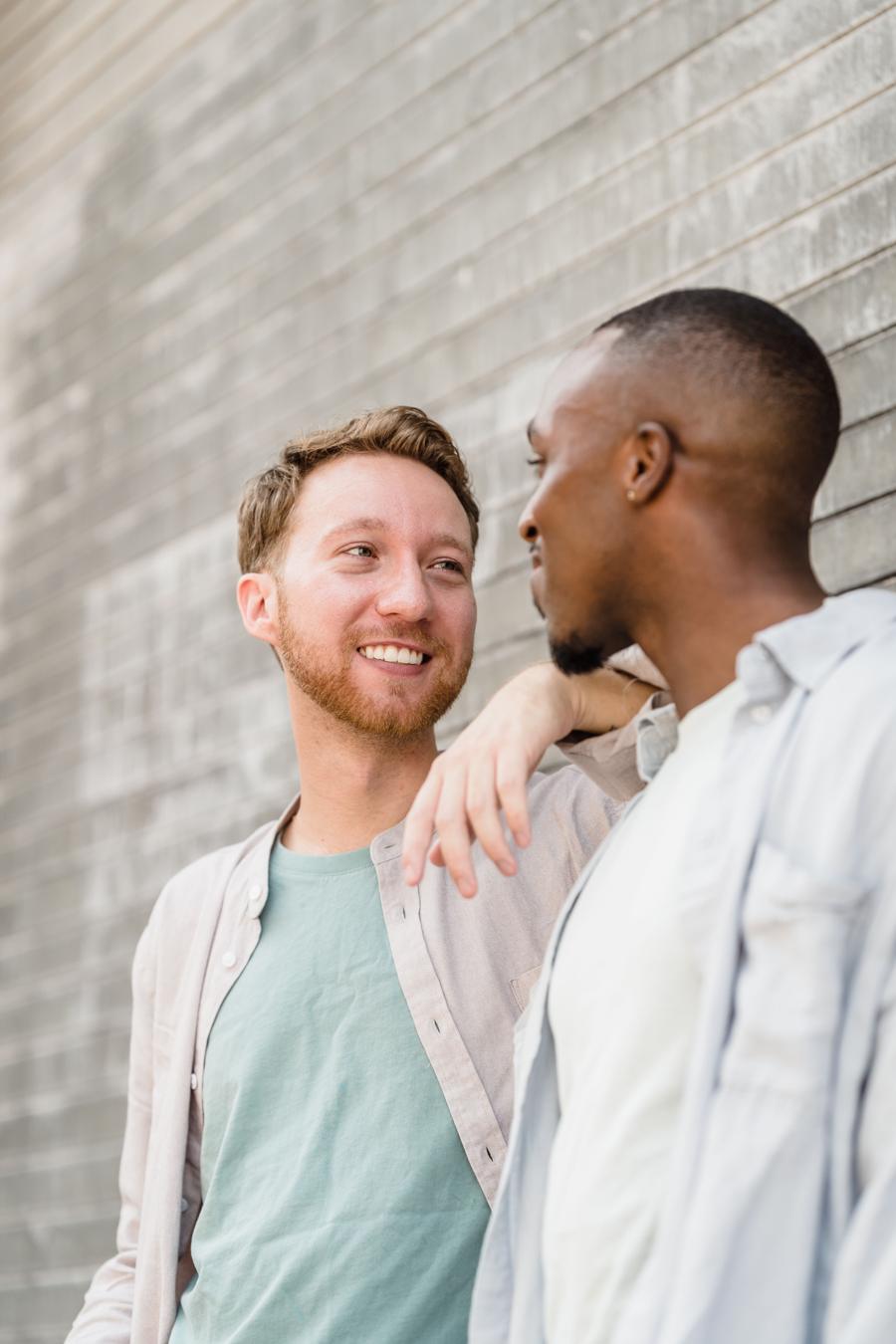 Two men smiling at each other, one with his arm on the other's shoulder